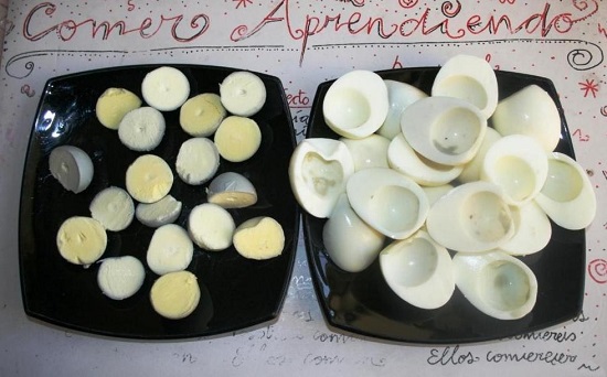 Аккуратно разрезаем яйца пополам и убираем желтки